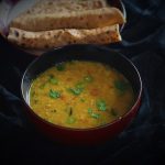 moong dal recipe in a bowl with chapati in the background