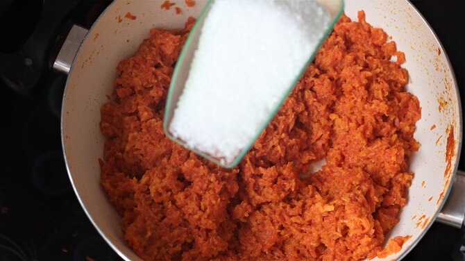 sugar being added to carrot halwa