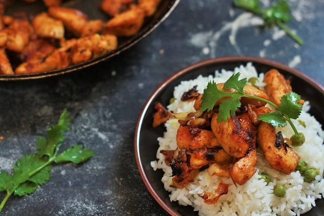 tawa chicken recipe on top of rice garnished with coriander leaves