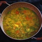 hyderabadi khatti dal recipe in a kadai with a black background