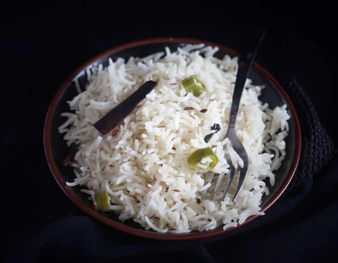 jeera rice recipe in a black plate with a fork
