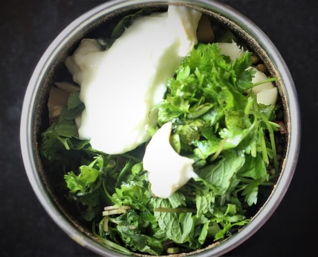 spices with coriander, mint leaves, yogurt in a mixie jar