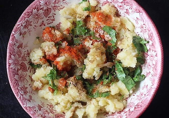 adding masala to mashed potatoes