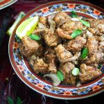 mutton varuval recipe in a plate with lemon wedges